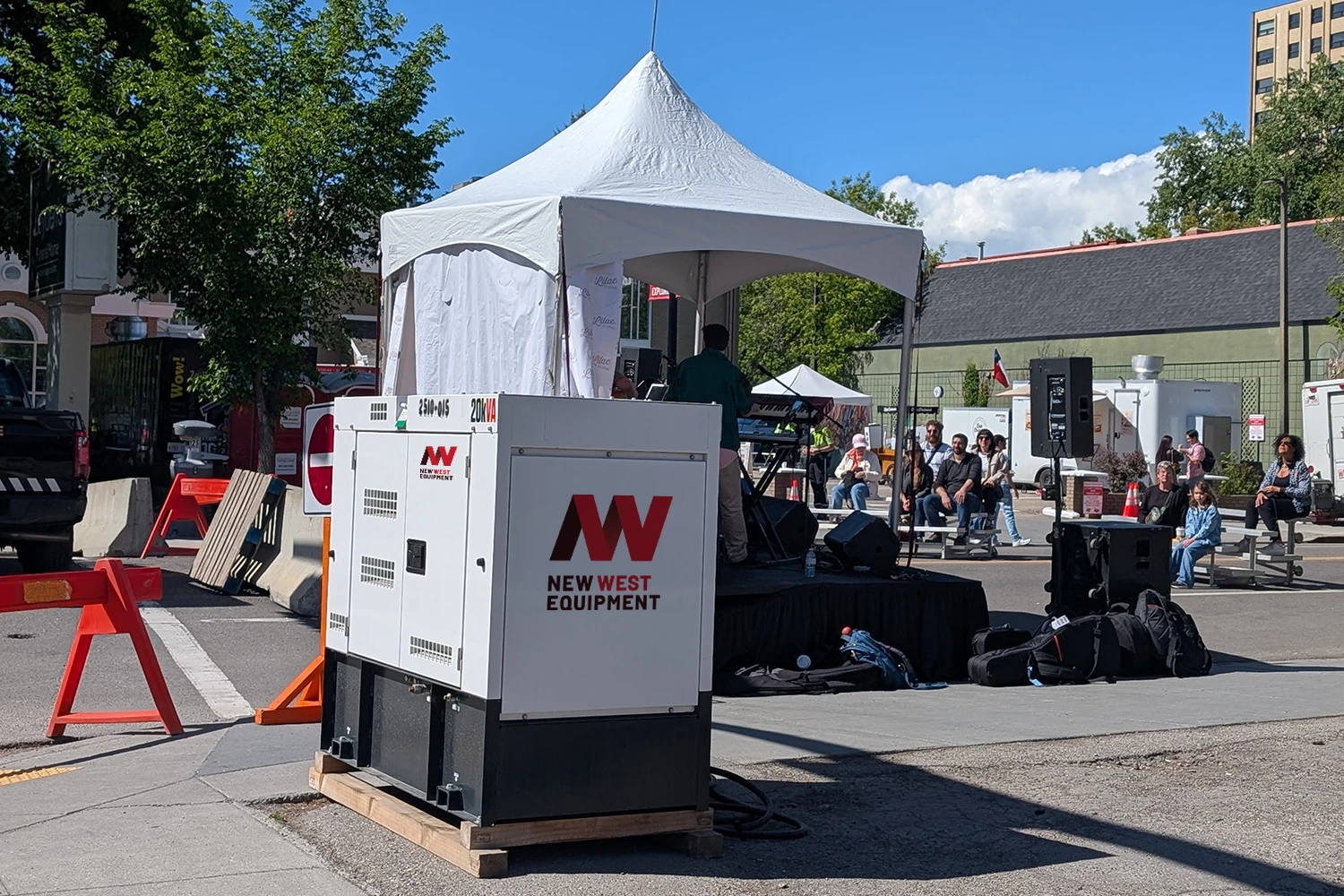 Portable generator from ACME Rental Equipment Company powering an outdoor event with a crowd and stage under a white canopy tent.